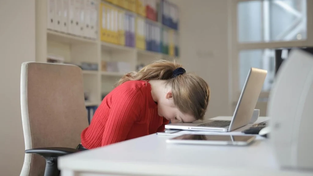 女性が職場で居眠りをしている画像