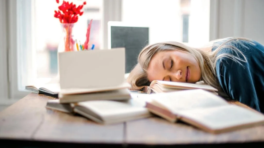 女性が机で仮眠をしている様子