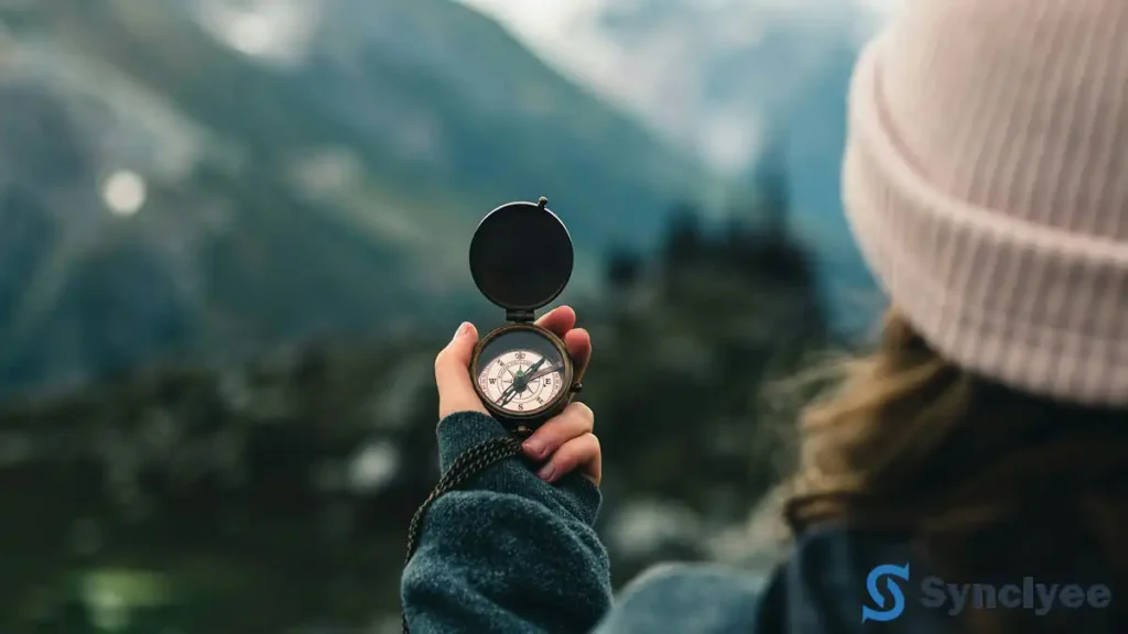 女性がコンパスを持って眺めている後ろ姿の画像