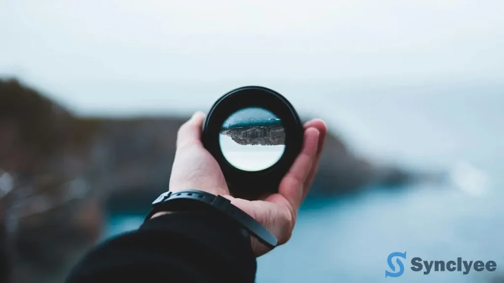 ピントの合ったカメラレンズを持つ手