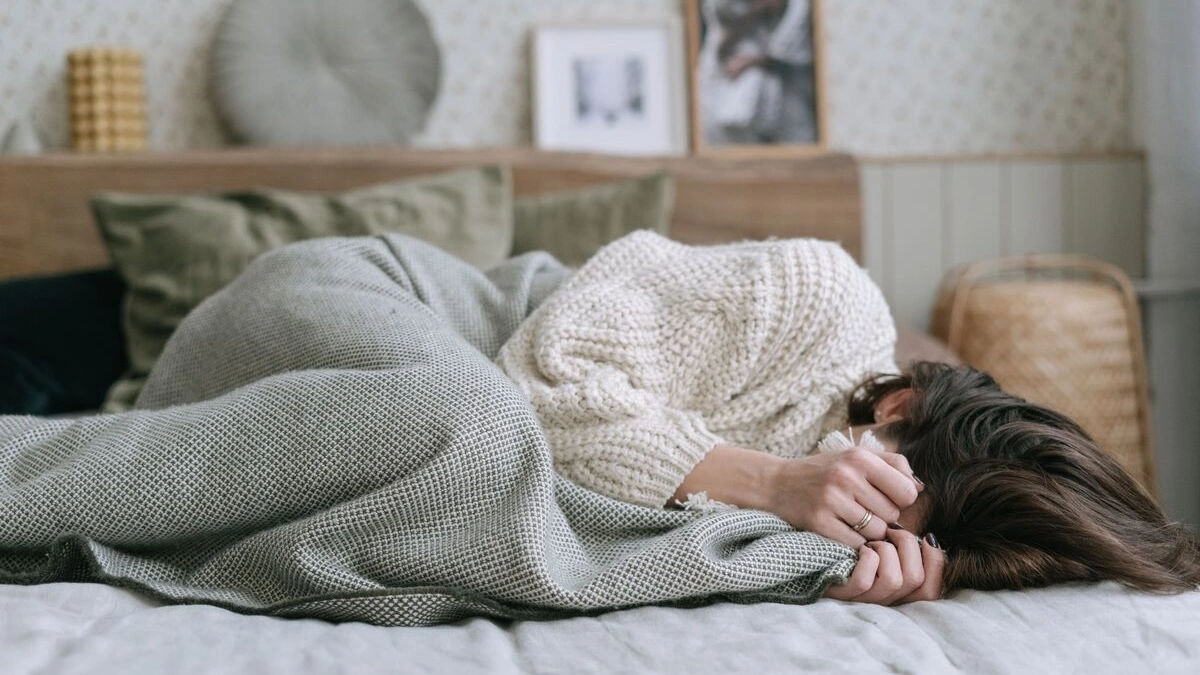 女性が悪夢を見てうずくまっている様子
